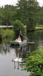 Mariés arrivant en barque sur la rivière avec des cygnes au Moulin des Planches lors de leur cérémonie laïque.