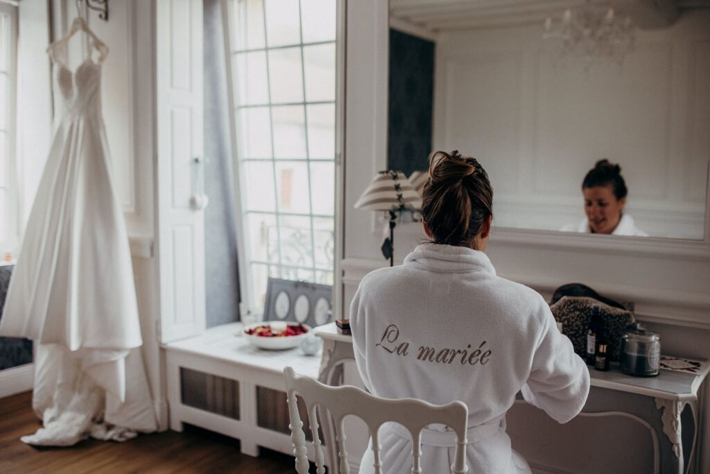 mariée qui se prépare en peignoir avant d'enfiler sa robe de mariée