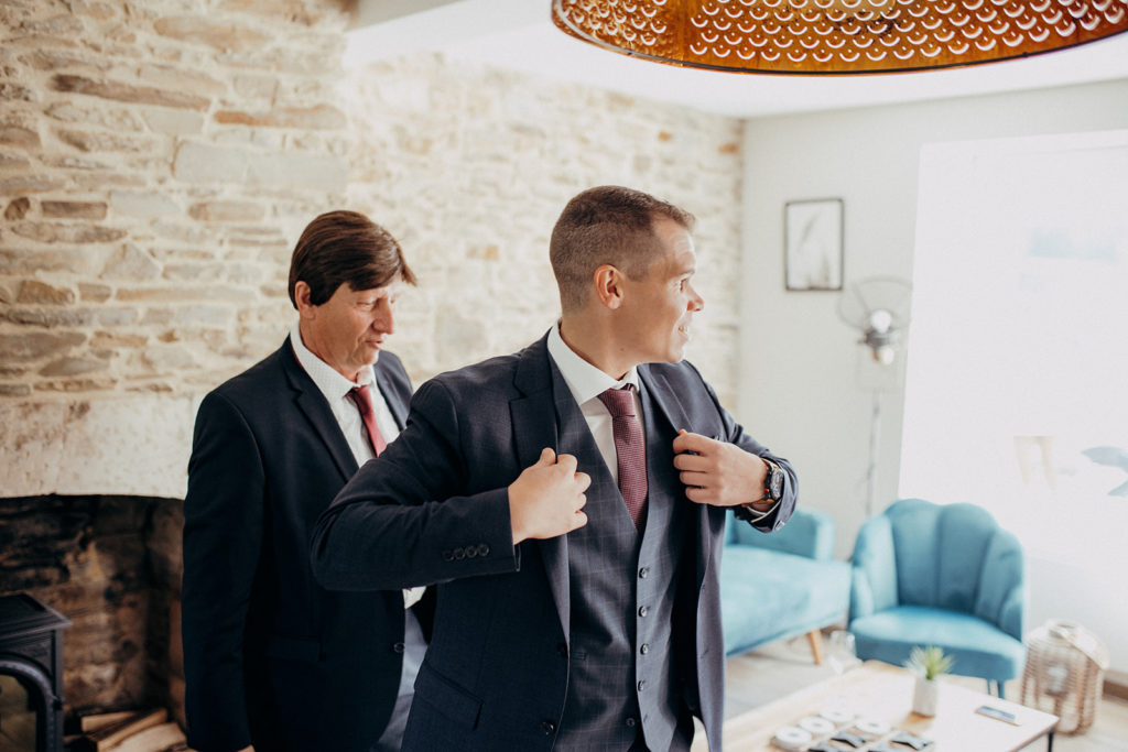 un papa et son fils s'habillant avant d'aller rejoindre la future mariée