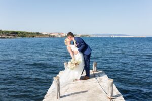 Le marié penchant sa mariée pour un baiser au bord de la mer en Sardaigne