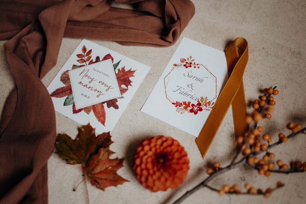 Flatlay de papeterie de mariage avec motifs de feuilles rousses et fleurs séchées